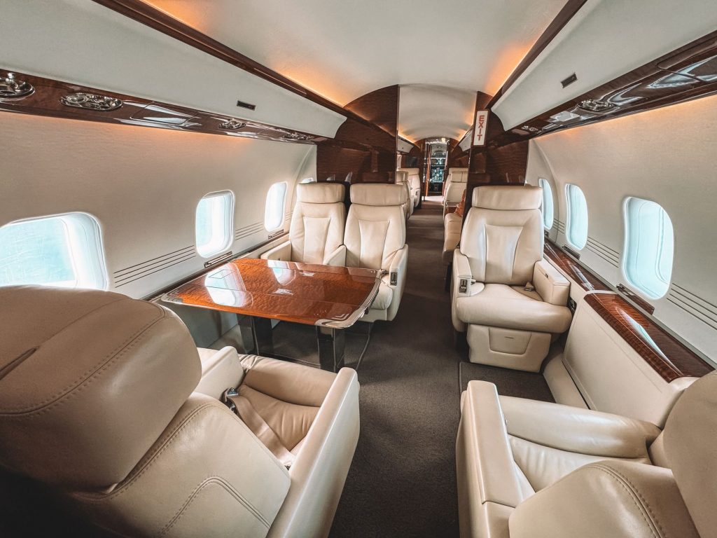 Luxuriöse Business-Class-Kabine in einem Flugzeug mit Ledersitzen und Holzverkleidung
