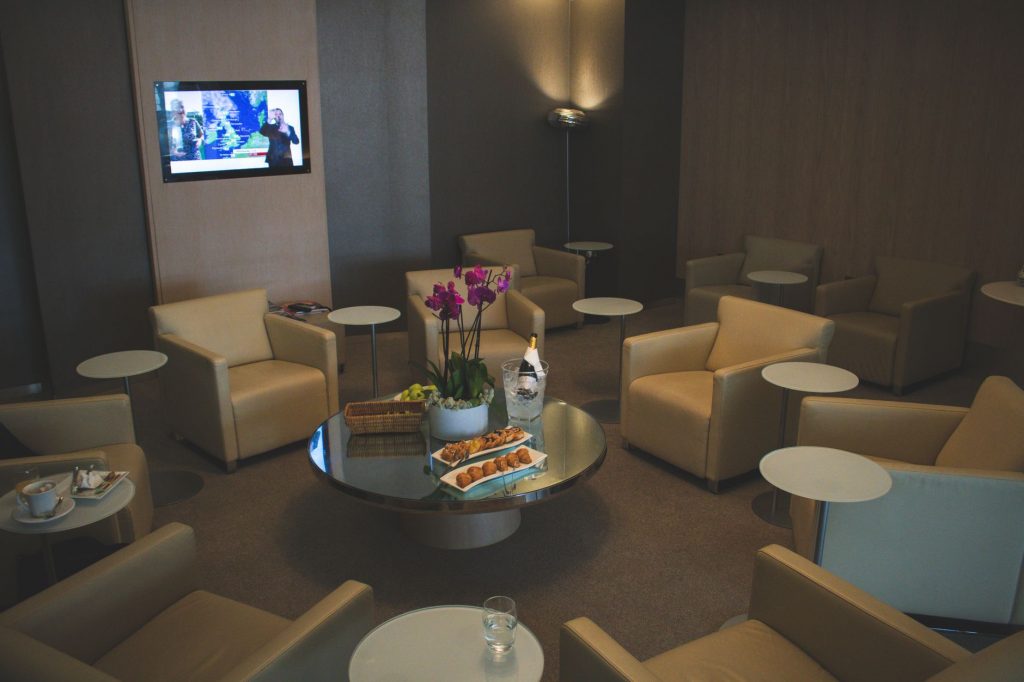 Elegante Flughafen-Lounge mit beigen Ledersesseln und Orchideendeko