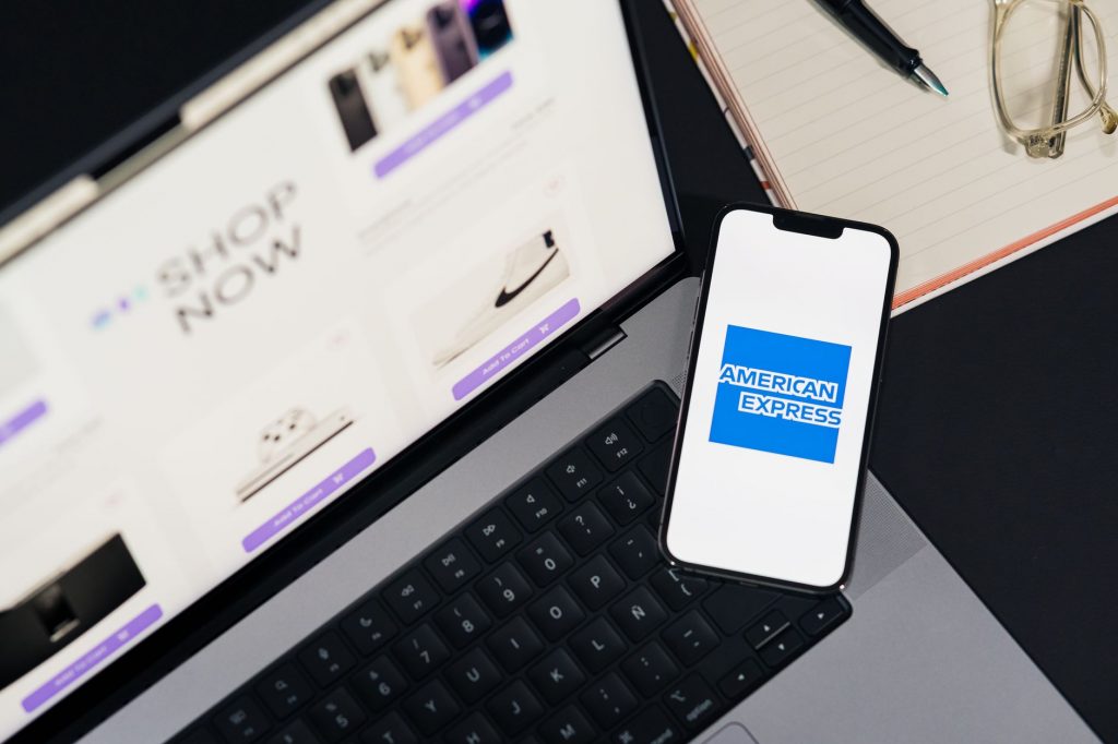 American Express Logo auf dem Smartphone vor einem Laptop