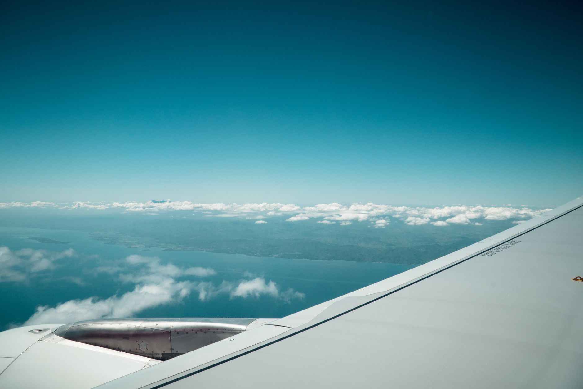 Blick aus dem Flugzeugfenster über den Wolken auf einem Langstreckenflug