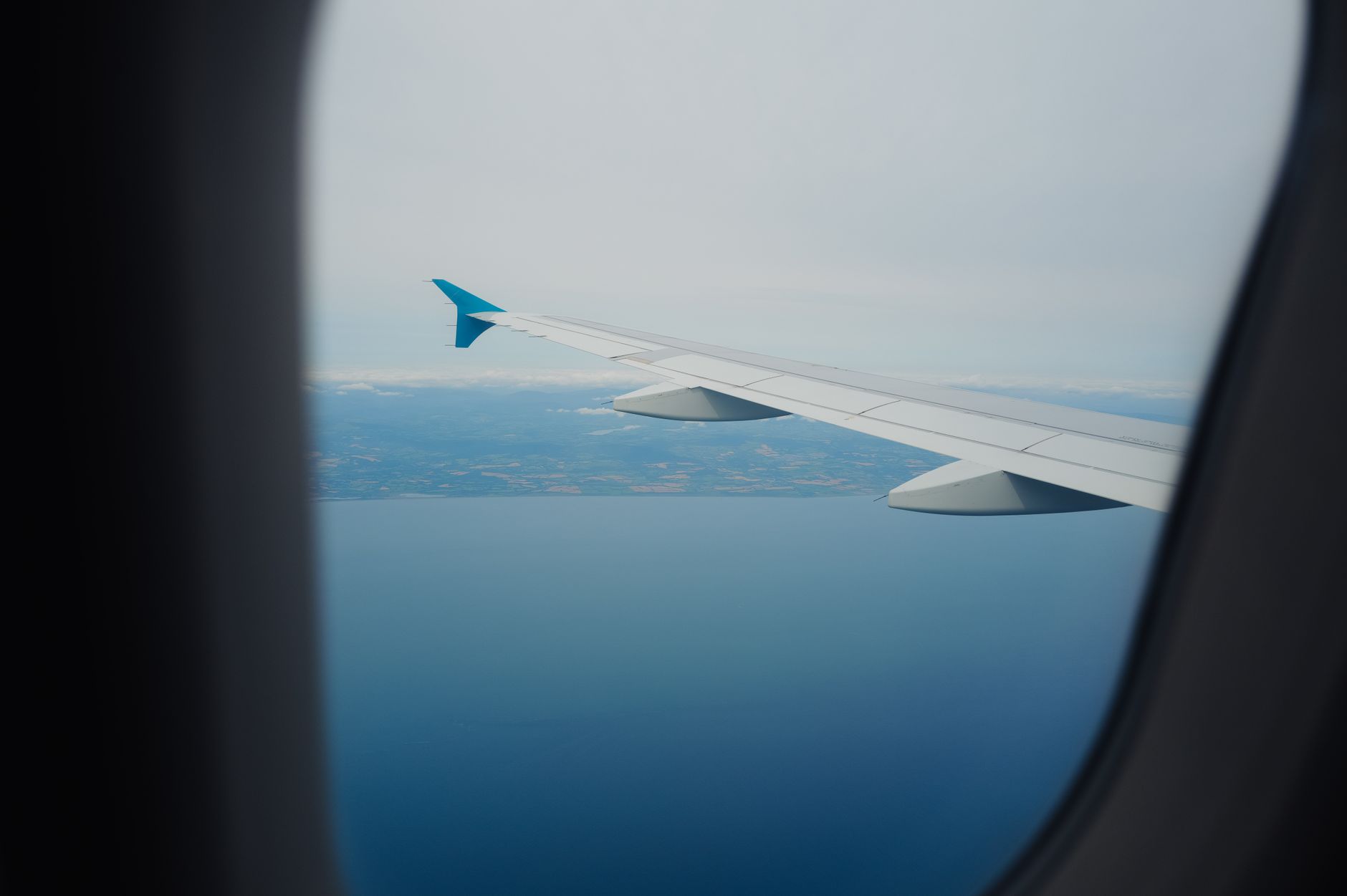 Blick aus dem Flugzeugfenster auf eine Wolkendecke