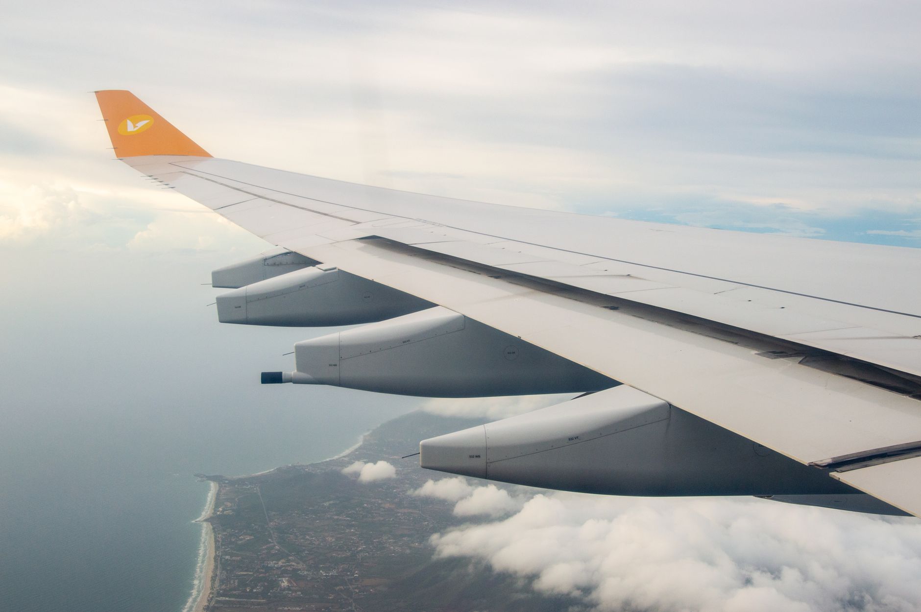Wolken und Tragfläche aus dem Flugzeugfenster – Reise mit den Leistungen der Miles & More Gold Credit Card