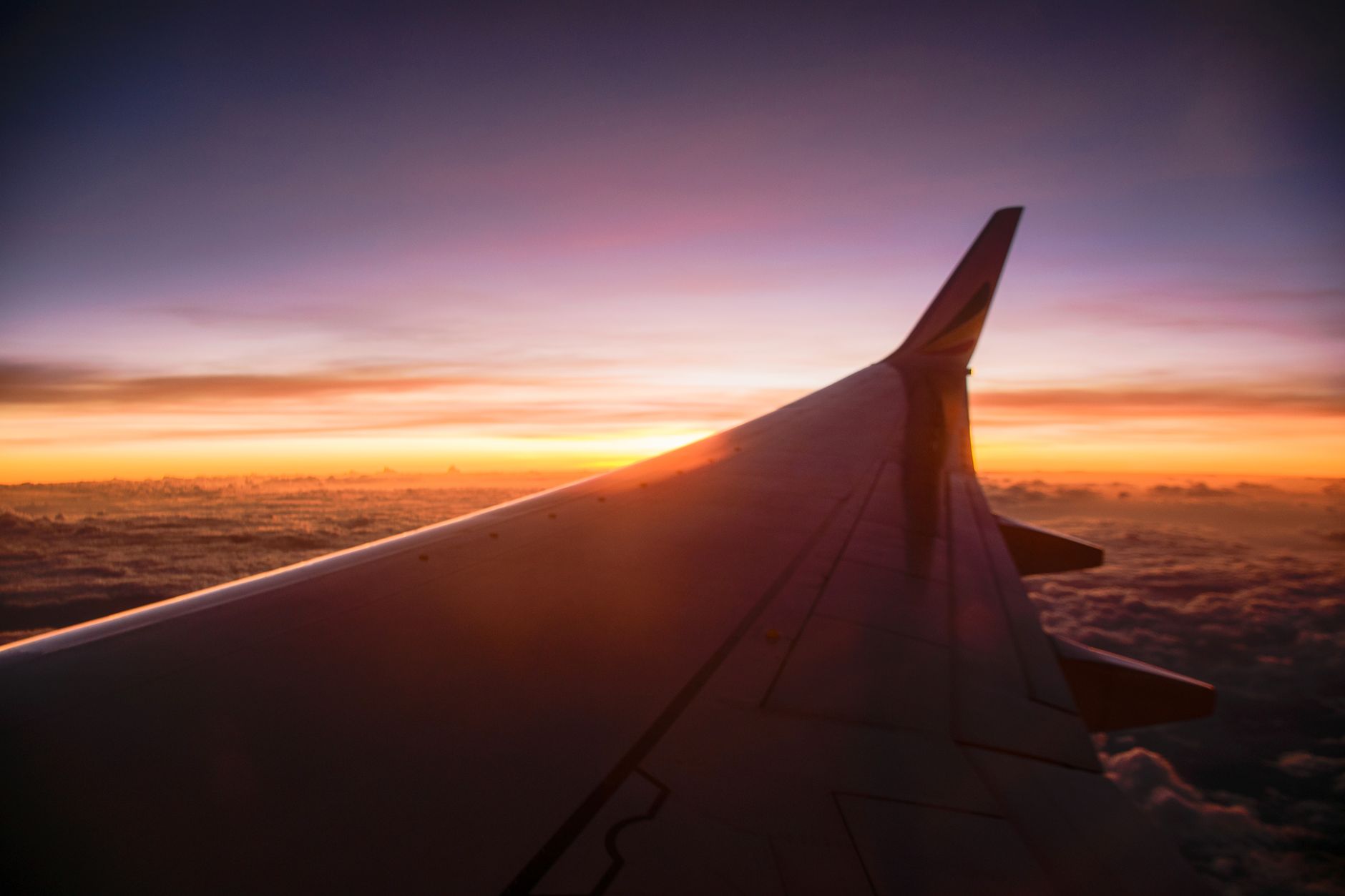 Blick aus dem Flugzeugfenster über den Wolken auf einem Langstreckenflug
