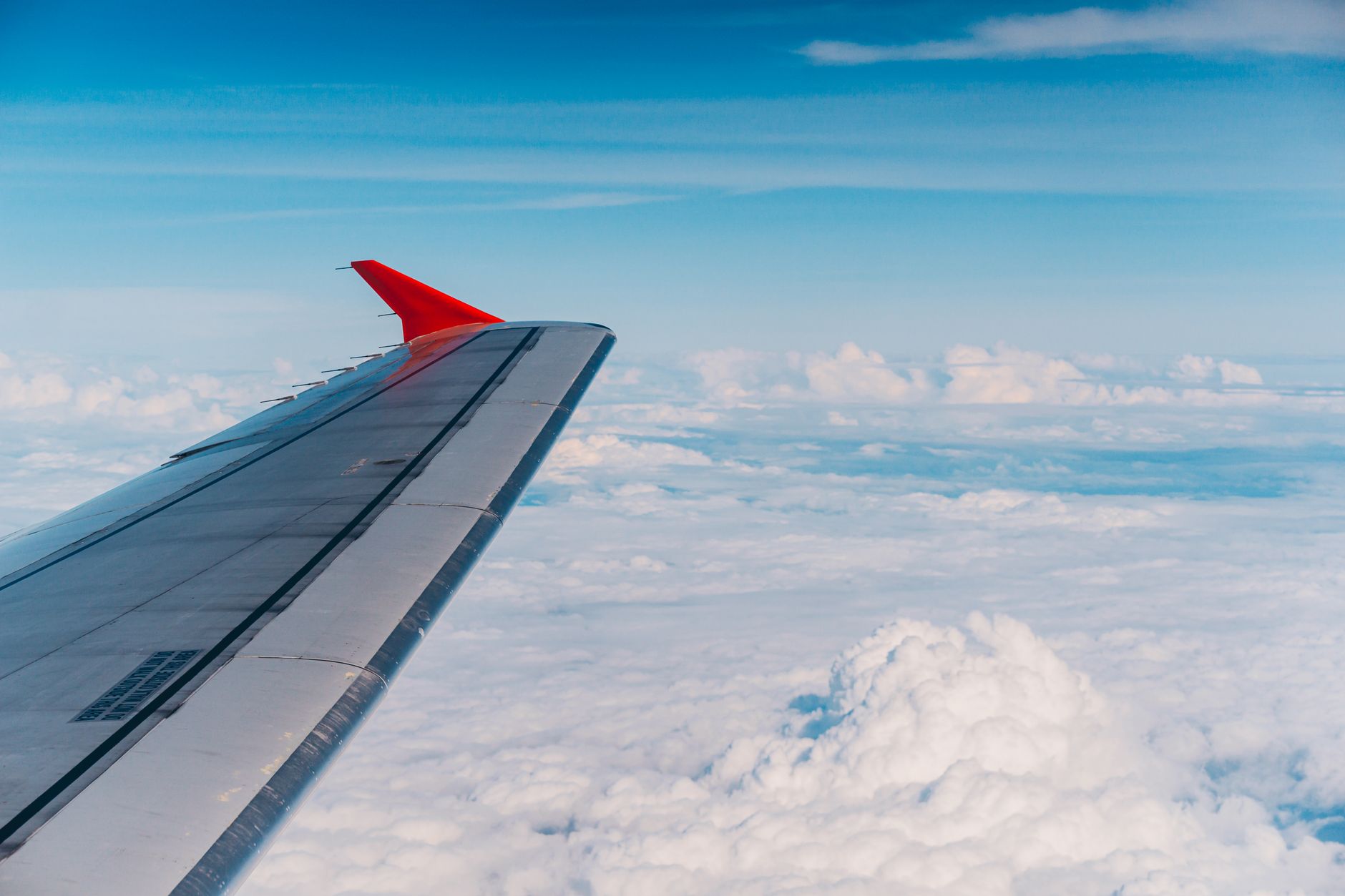 Wolkenmeer aus dem Flugzeugfenster – Geschäftsreise mit Versicherungsschutz der Gold Business Karte