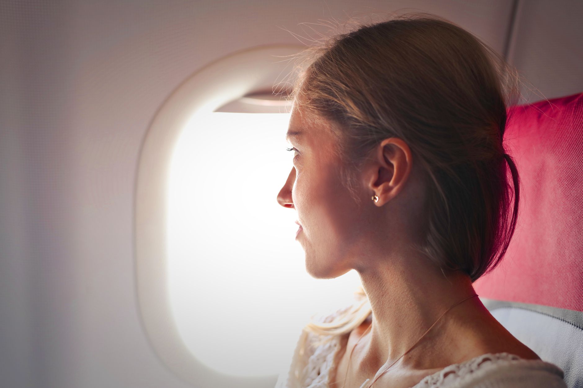 Reisende am Flugzeugfenster – mit Miles & More Meilen in die Business Class